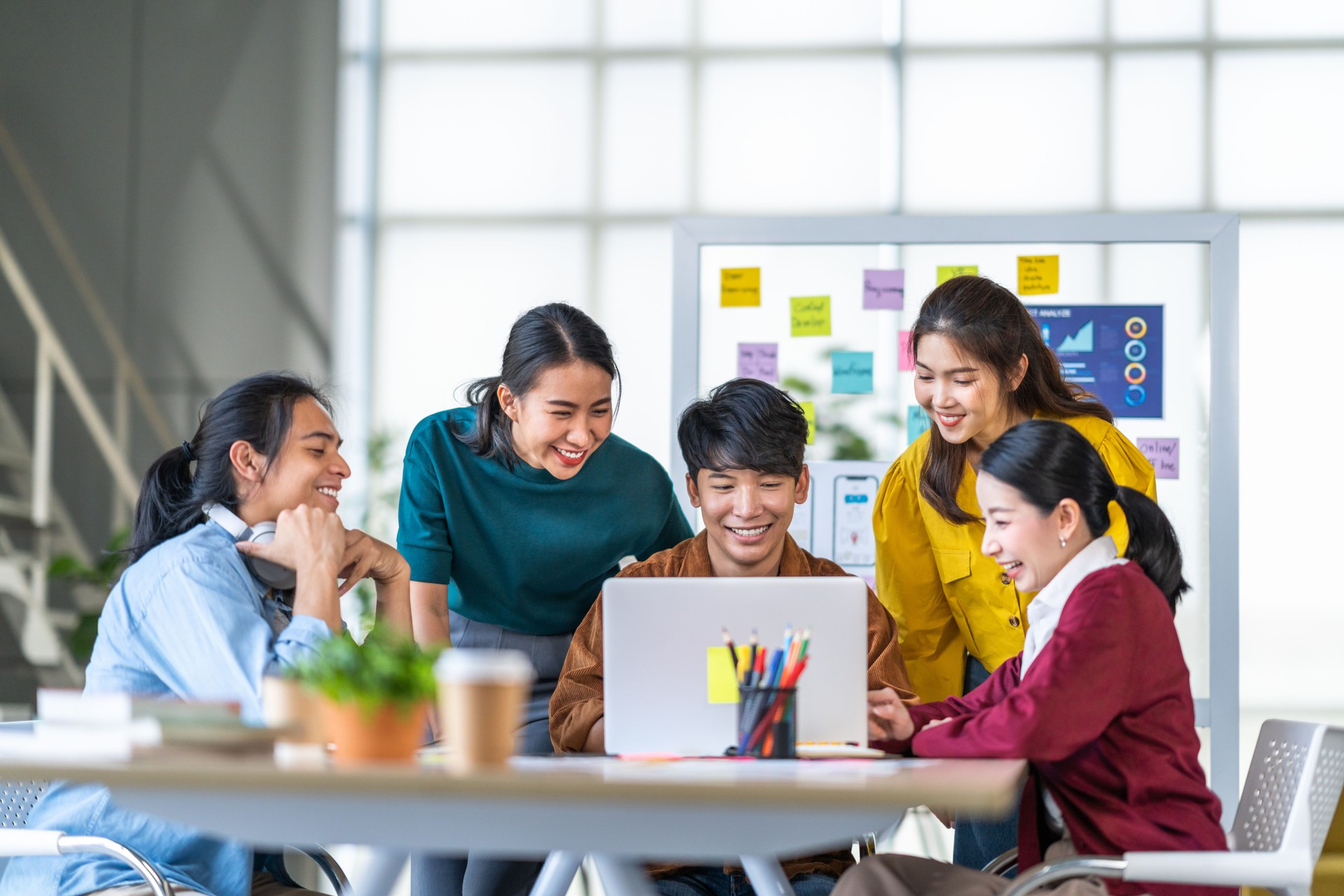 Young happy Asian business man, woman work together in start up office. Creative team brainstorm meeting, internet technology, businesspeople colleague partnership, or office coworker teamwork concept